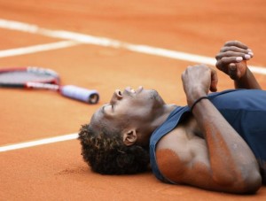 France's Gael Monfils lies on the court during his semi-final match against Switzerland's Roger Federer at the French Open tennis tournament at Roland Garros in Paris