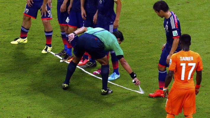 Referee Enrique Osses marks line during World Cup soccer match between Ivory Coast and Japan at Pernambuco arena