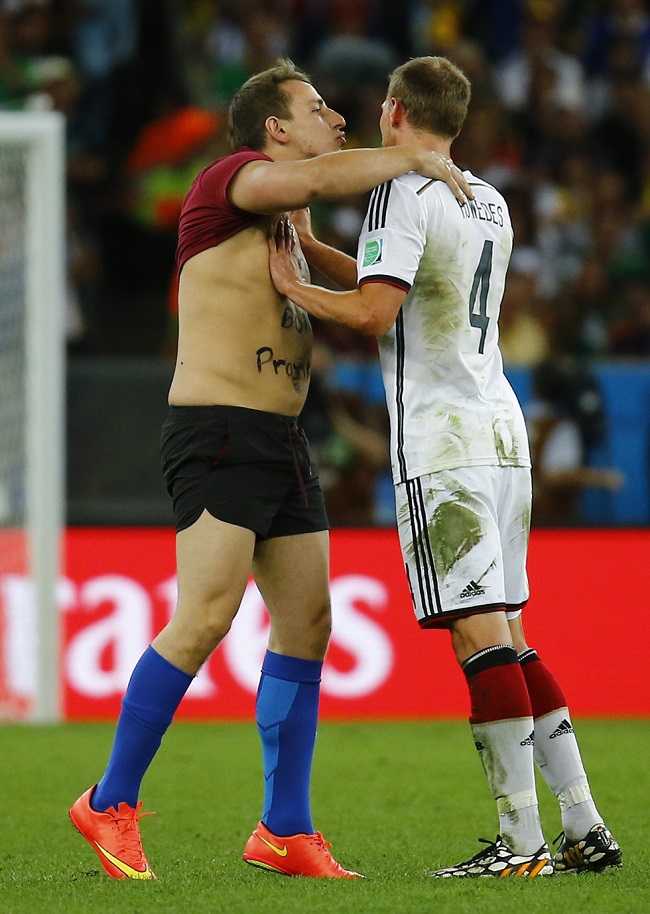 Germany's Hoewedes pushes away a fan who invaded the pitch during the team's 2014 World Cup final against Argentina in Rio de Janeiro
