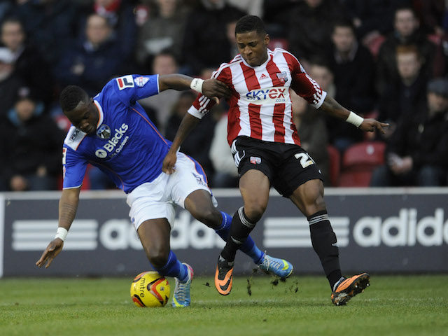 LONDON, ENGLAND - DECEMBER 14: Genseric Kusunga of Oldham Athletic is tackled by Kadeem Harris of Brentford during the Sky Bet League One match between Brentford and Oldham Athletic at Griffin Park on December 14, 2013 in London, England. (Photo by Rob Munro/Getty Images)