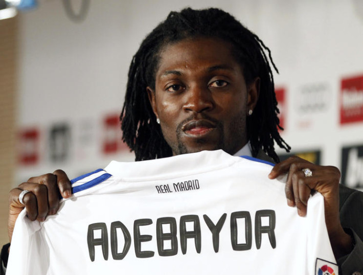 Former Manchester City player Emmanuel Adebayor holds up his new Real Madrid jersey during his presentation at the Santiago Bernabeu stadium in Madrid, January 27, 2011. Adebayor was signed on loan until the end of the season. REUTERS/Sergio Perez (SPAIN - Tags: SPORT SOCCER)