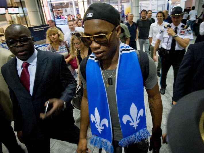 MONTREAL, QUE.: WEDNESDAY, JULY 29, 2015 -- Didier Drogba is escorted through Pierre Trudeau Airport in Montreal, Quebec, on July 29, 2015. Drogba arrived from London England and was greeted by hundreds of chanting fans. (Frederic Hore / MONTREAL GAZETTE)
